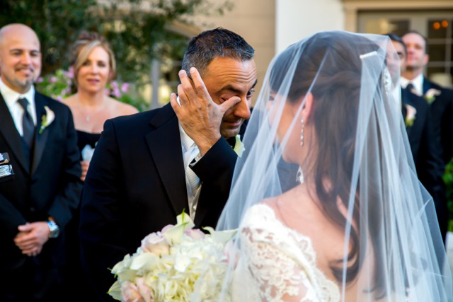 The groom gets overwhelmed with emotion. He stops to wipe away his tears, and a pearl of a moment is revealed. 